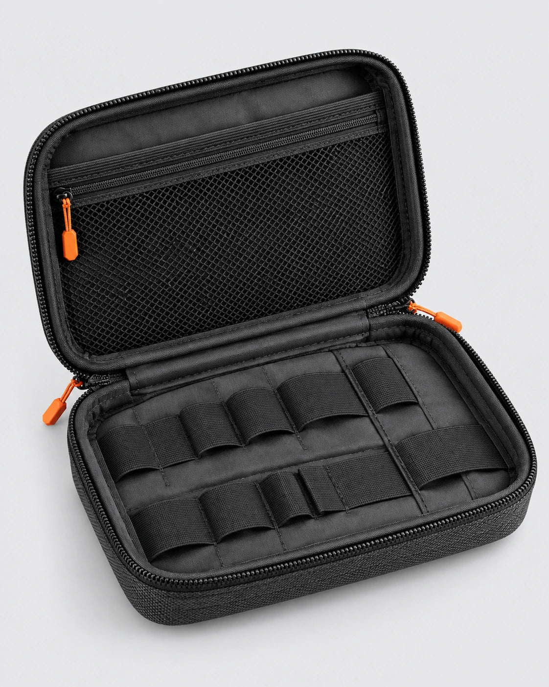 Open charcoal tech organiser case with mesh pocket, internal loops and orange zip pulls on a grey background.