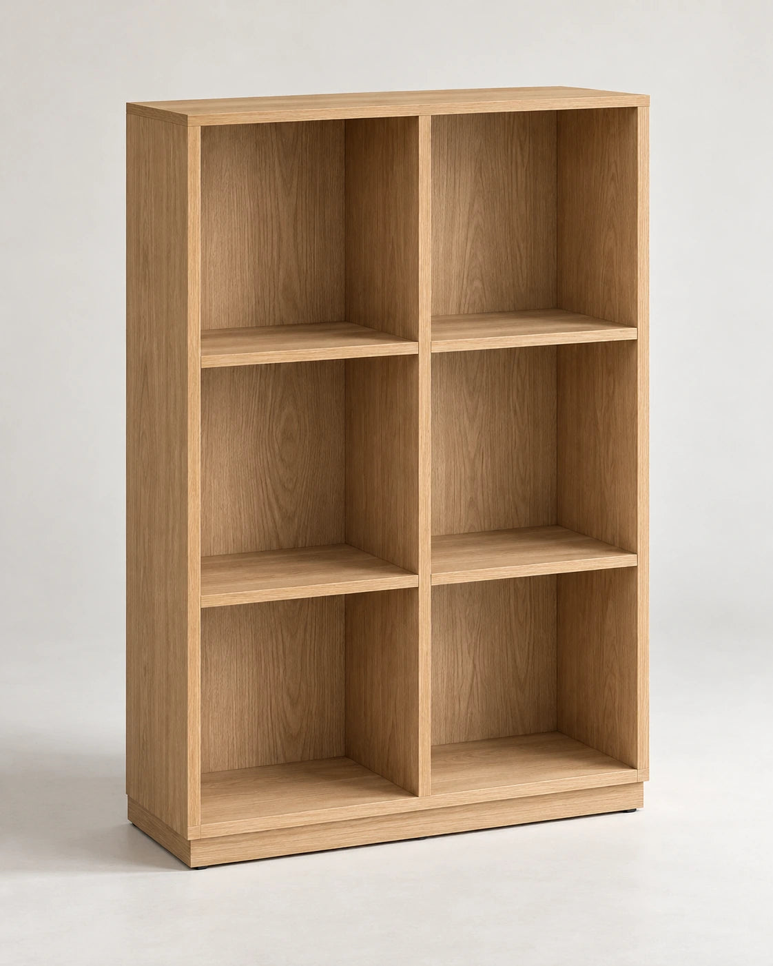 Empty oak shelving unit with six evenly spaced open compartments on a pale studio floor.
